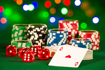 Gambling concept - cards with bones and chips on the background of bokeh lights