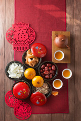 Flat lay Chinese new year food and drink still life. Translation of text in image: Prosperity.