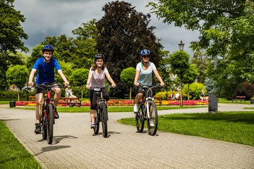 Naklejka premium Healthy lifestyle - people riding bicycles in city park