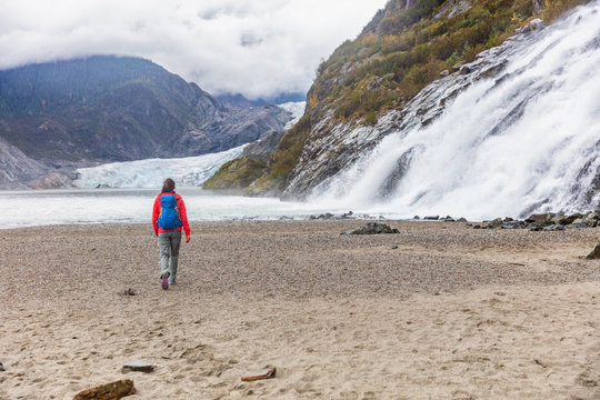 Mendenhall glacier in Juneau, Alaska. Woman tourist walking at famous attraction excursion on USA travel cruise.
