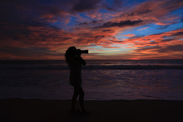 Fototapeta premium Girl Photographer Taking Pictures With Dslr Camera At Sunset On The Beach