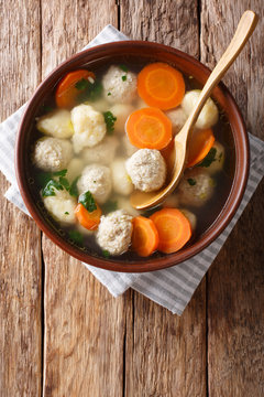 Closeup homemade chicken soup with meat balls, dumplings and vegetables in a bowl. Vertical top view