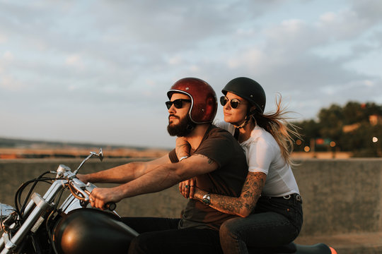Fototapeta Biker couple riding down the road in the sunset