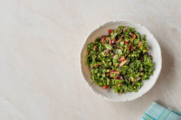 Chopped Parsley Salad with Tomatoes and Onions in Ceramic Bowl on Marble Surface.