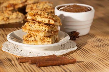 homemade apple pie on a white plate which stands on an old wooden table close-up with a copy space