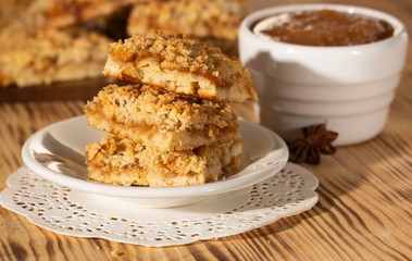 homemade apple pie on a white plate which stands on an old wooden table close-up with a copy space