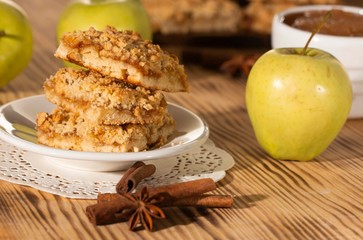 homemade apple pie on a white plate which stands on an old wooden table close-up with a copy space
