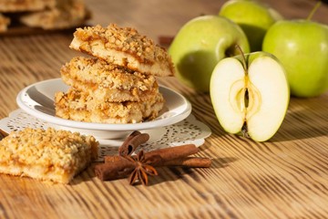 homemade apple pie on a white plate which stands on an old wooden table close-up with a copy space