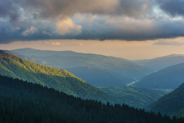 Mountain spring landscape with a small meadow in the valley.