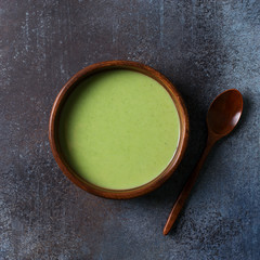 Green vegetable soup on dark grey background minimalism