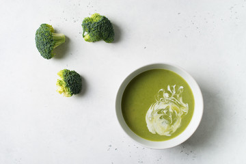 Green vegetable broccoli soup on white background minimalism