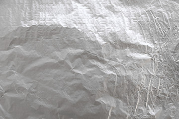 Aluminum crumpled foil background. Silver baking foil texture.