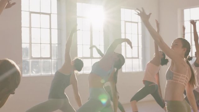 yoga class multi ethnic women practicing reverse warrior pose enjoying healthy lifestyle exercising in fitness studio at sunrise