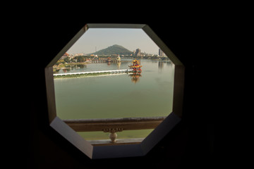 View through hexagonal window of Taiwanese taoist temple on lake