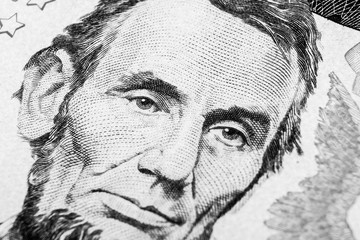 Close up view Portrait of Abraham Lincoln on the one five dollar bill. Background of the money. 5 dollar bill with Abraham Lincoln eyes macro shot. Money background. Face portrait. Black and white
