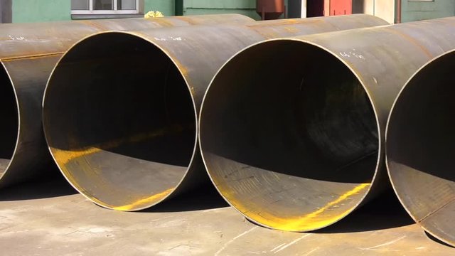 Stack of new metal pipes. Industrial material. Steel pipe. Large diameter welded pipes. Welded pipe with a spiral seam.