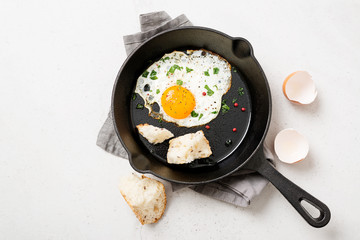 Fried egg for delicious healthy easy breakfast on a table. Fresh homemade meal on a frying pan.