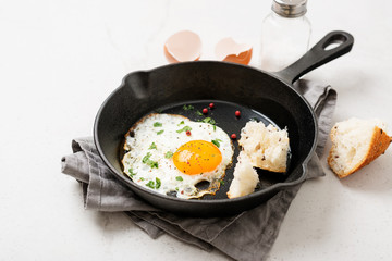 Fried egg for delicious healthy easy breakfast on a table. Fresh homemade meal on a frying pan.