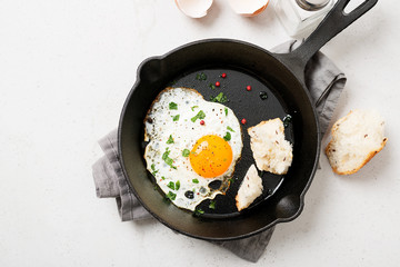 Fried egg for delicious healthy easy breakfast on a table. Fresh homemade meal on a frying pan.