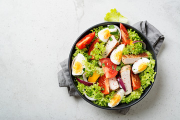Fresh vegetable salad with chicken breast and eggs.