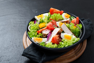 Fresh vegetable salad with chicken breast and eggs.
