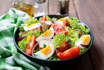 Fresh vegetable salad with chicken breast and eggs.