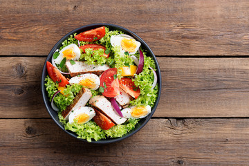 Fresh vegetable salad with chicken breast and eggs.