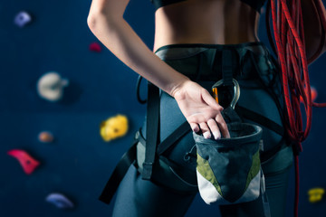 Obraz premium Successful strong self confident sport woman female alpinist climber staying opposite wall before training bouldering on climbing wall. Preparing for complex competition and ready for win concept.