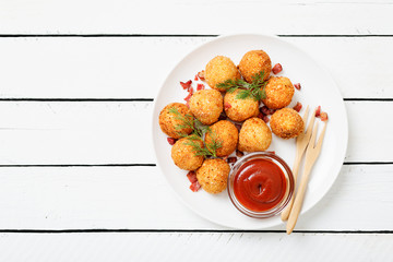 Potato croquettes - mashed potatoes balls breaded and deep fried, served with different sauce.