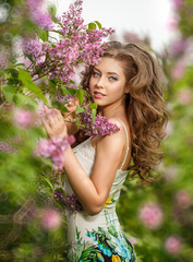 Fototapeta premium Beautiful Young Woman near the Blossoming spring tree. Model in blossom park.