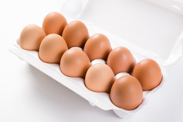 ten brown eggs in white package side view close-up