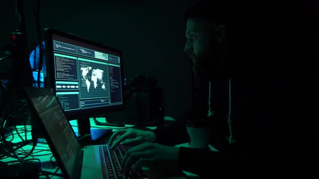 Wanted hackers coding virus ransomware using laptops and computers in the basement. Cyber attack, system breaking and malware.