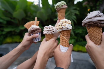 portrait of hands holding ice cream cone background green trees