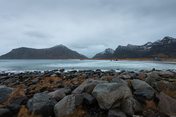 Landscape of long exposure rocks beach with overcast sky in Lofoten Norway