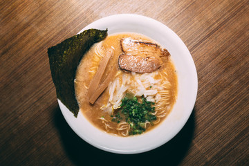 Top view of Ramen Pork Bone Soup (Tonkotsu Ramen) with Chashu Pork, Scallion, Sprout, Onion, Menma and Dried Seaweed.