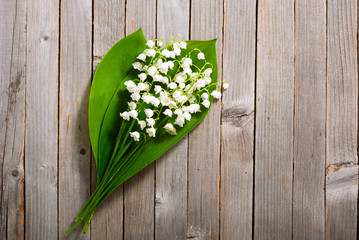 bouquet of lily of the valley on old weathered wooden table background