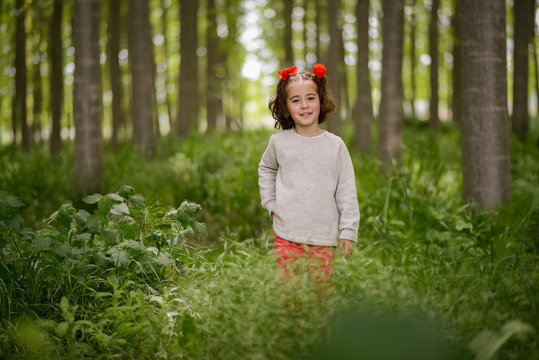 Cute little girl having fun in a poplar forest