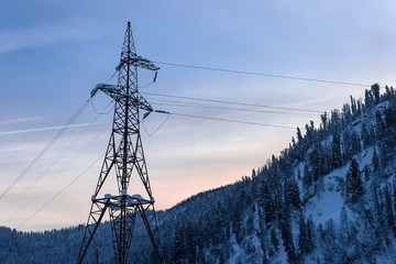 Electric tower on the background of snowy mountains