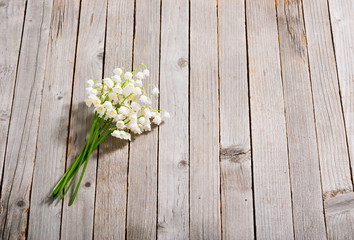 bouquet of lily of the valley flowers on old weathered wooden table background