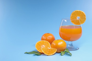 Oranges and Orange juice on summer blue sky background with copy space.