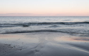 Fototapeta premium Calm waves in the cold sea on the shores of Gotland in the Baltic Sea. Late one winter afternoon.