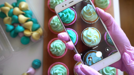 Photographing cupcakes on the phone. Confectionery camera shooting