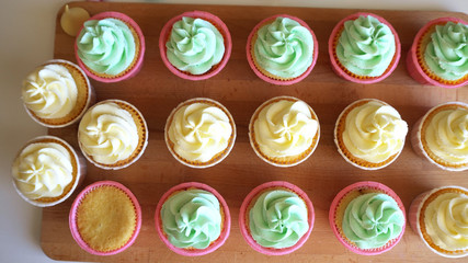 Confectioner decorates cupcakes with cream