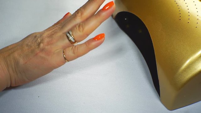 Woman dries her nails with shellac in UV lamp. Close-up. 1920X1080 Full Hd.