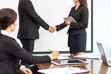 Two business people shaking hands conference training in meeting room ,finishing up a meeting.Business partners handshake while success job and project,greeting business deal,learning coaching concept