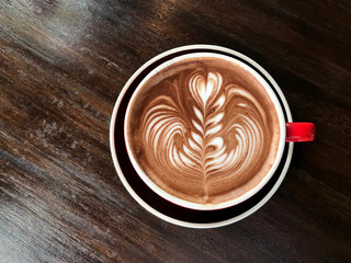 ็Hot coffee cup with latte art on wooden table. Coffee drink concept 