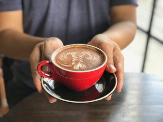 Coffee cup in man's hands in coffee shop