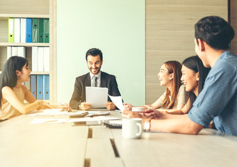 Teamwork business concept .Start up business people in modern office, working together having success. Multiethnic start-up business team on meeting in modern bright office interior brainstorming