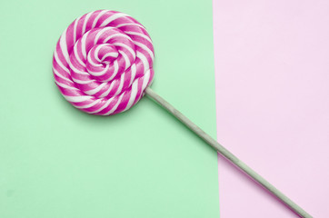 lollipop, a beautiful red and white striped lollipop on a green-pink background