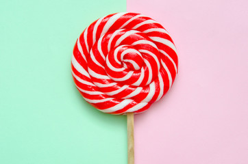 lollipop, a beautiful red and white striped lollipop on a green-pink background
